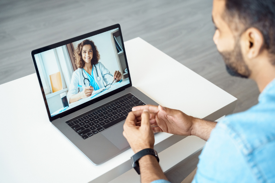 A man visits with a doctor through a video call.