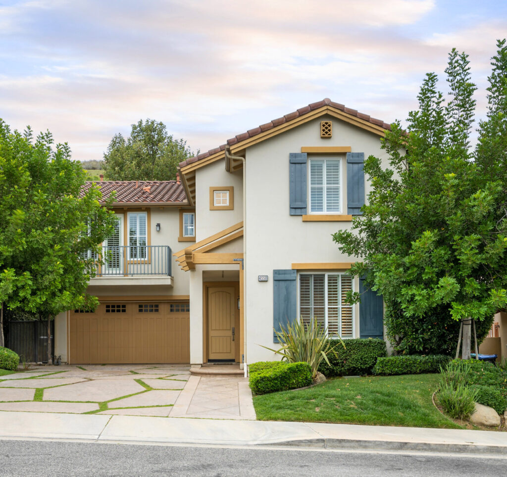 Two-story house with a garage and front yard trees. California, USA