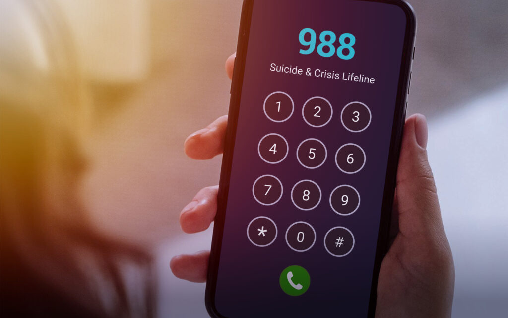 a smart phone user dialing 988